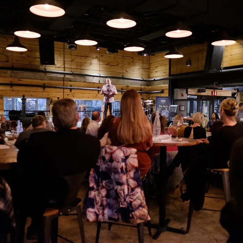 A full room of guests watching a storyteller at Empire