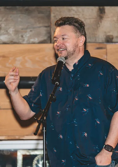A storyteller with a microphone on the Empire stage